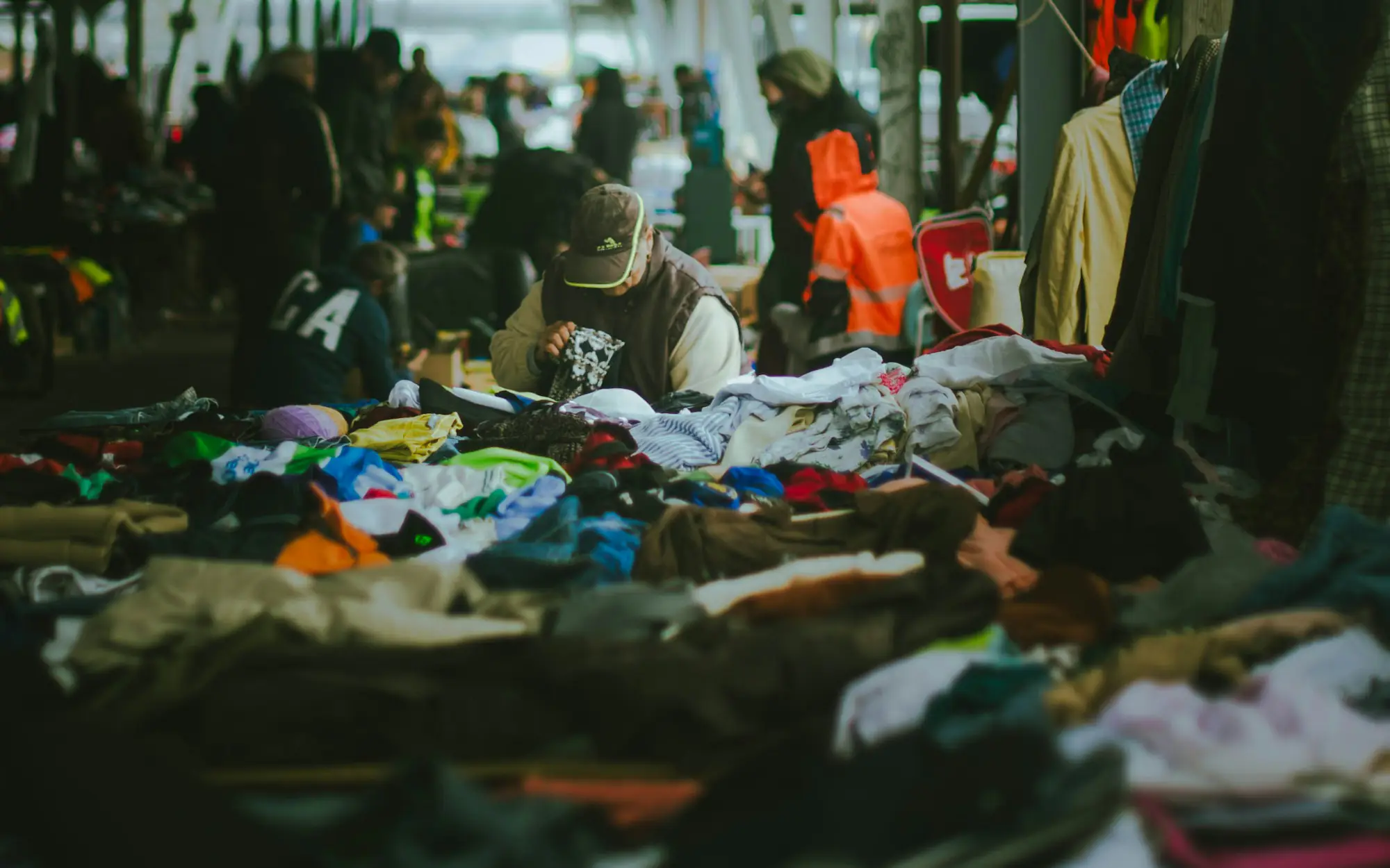 Shoppers digging through a pile of clothes at the bins